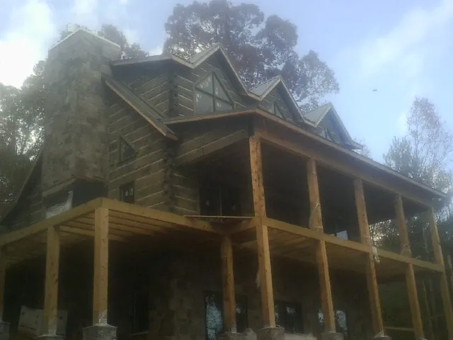 Stone chimney and dormers on a large log home with a timber porch in Rosalia